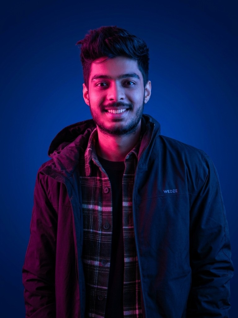 Rawshn smiling in a blue WEDZE jacket and plaid shirt